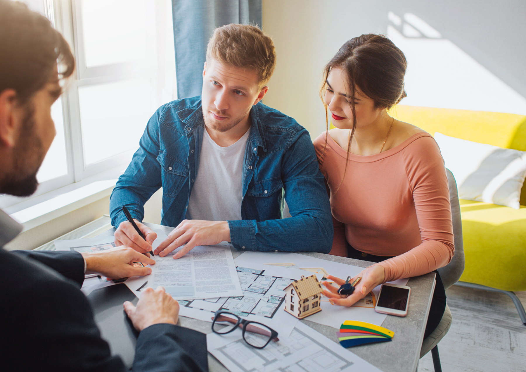 young couple with a real estate agent understanding buying a home. 