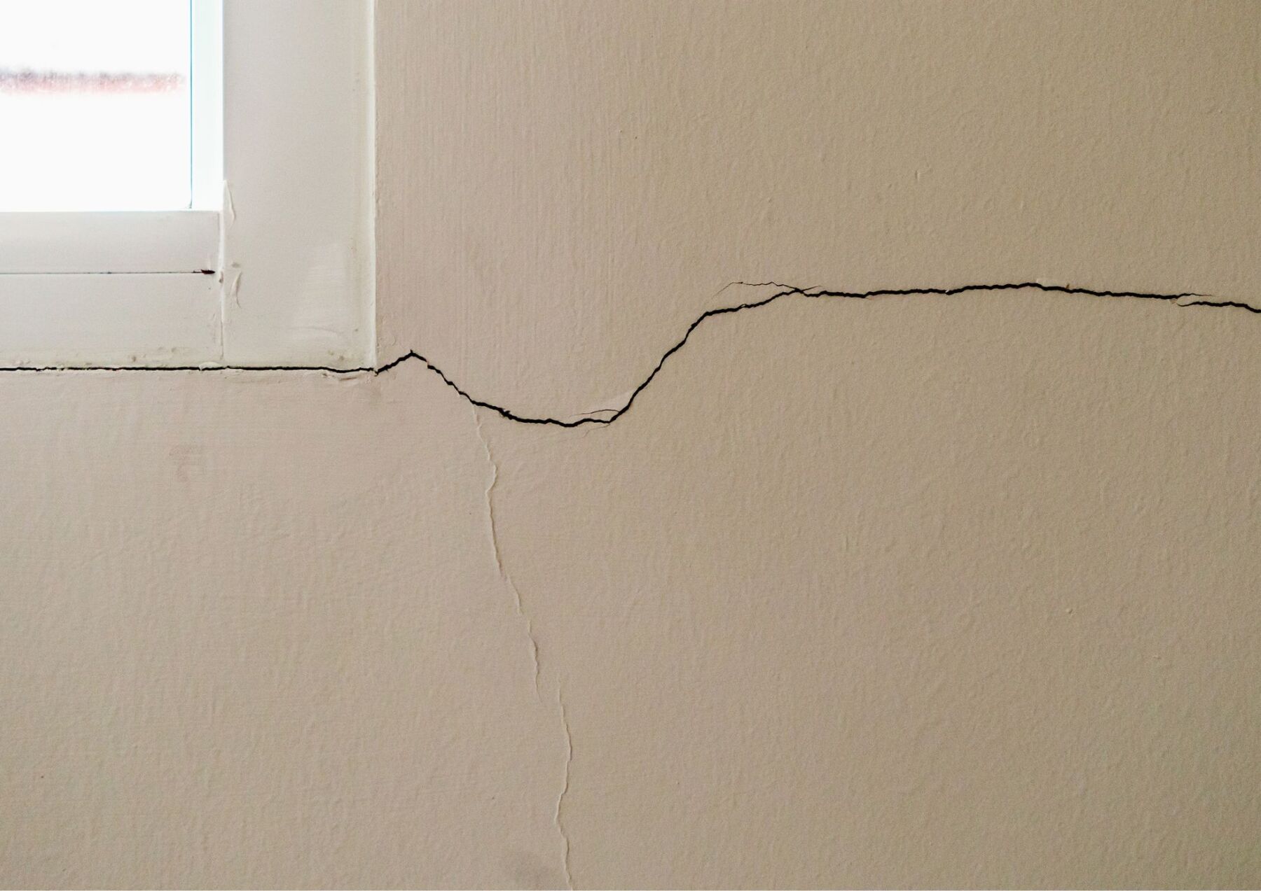 cracks in drywall around a window frame, signaling problems with the home foundation. 