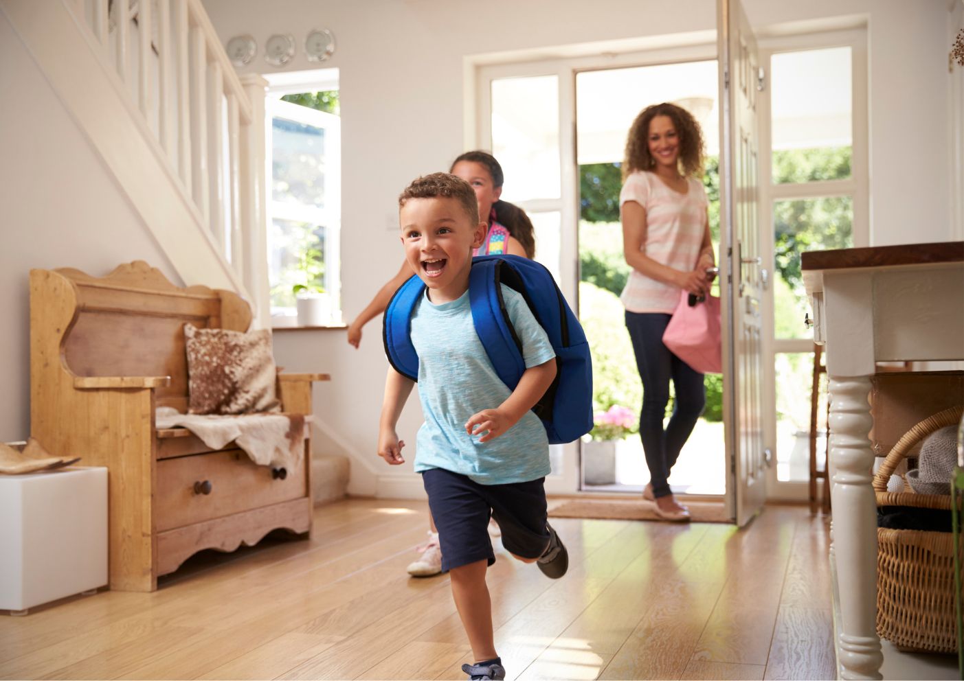 Happy kids running into a house from school. Single family home. 